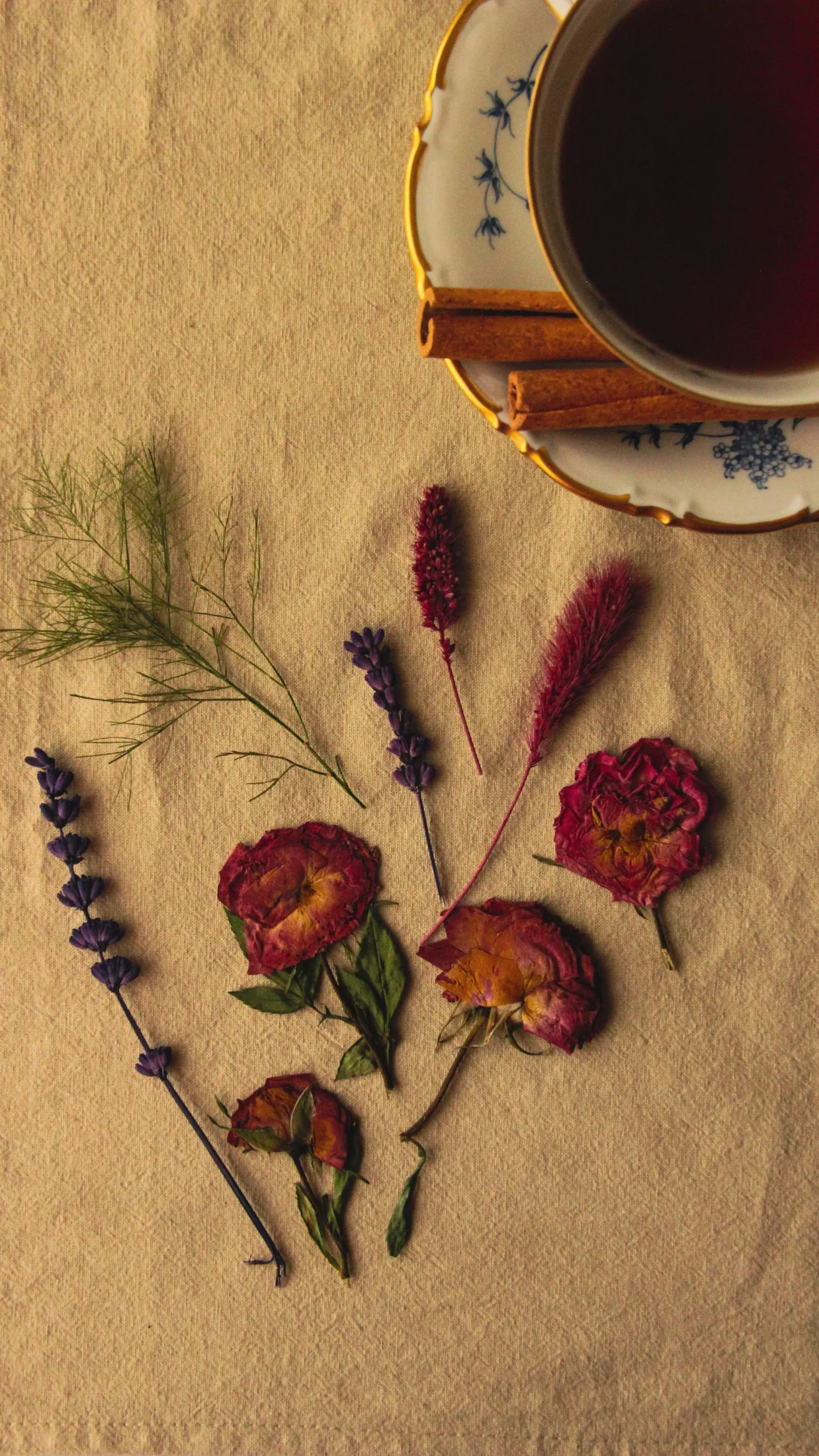 A cup of tea with dried flowers on linen