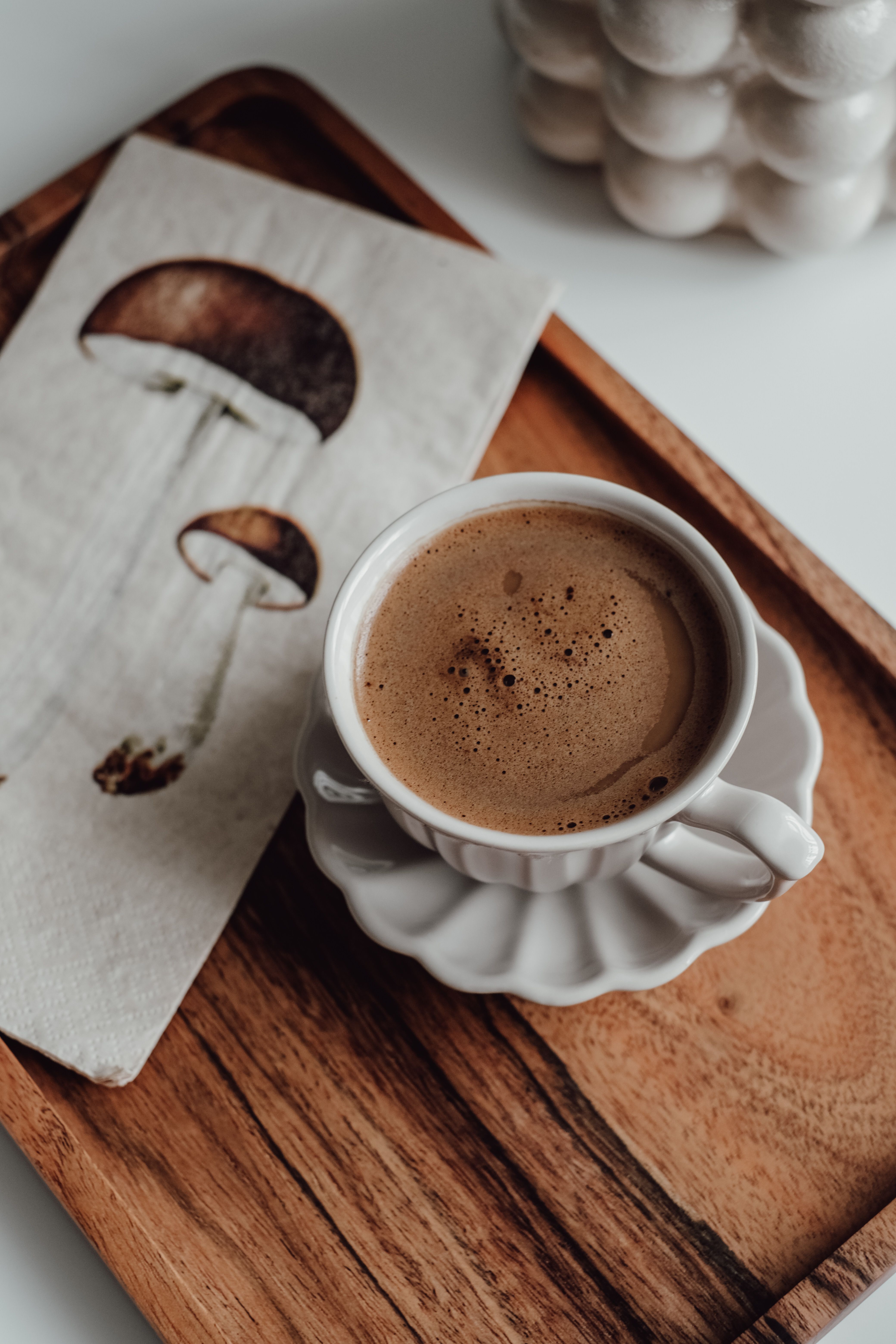 Unbranded coffee cup beside a mushroom illustration