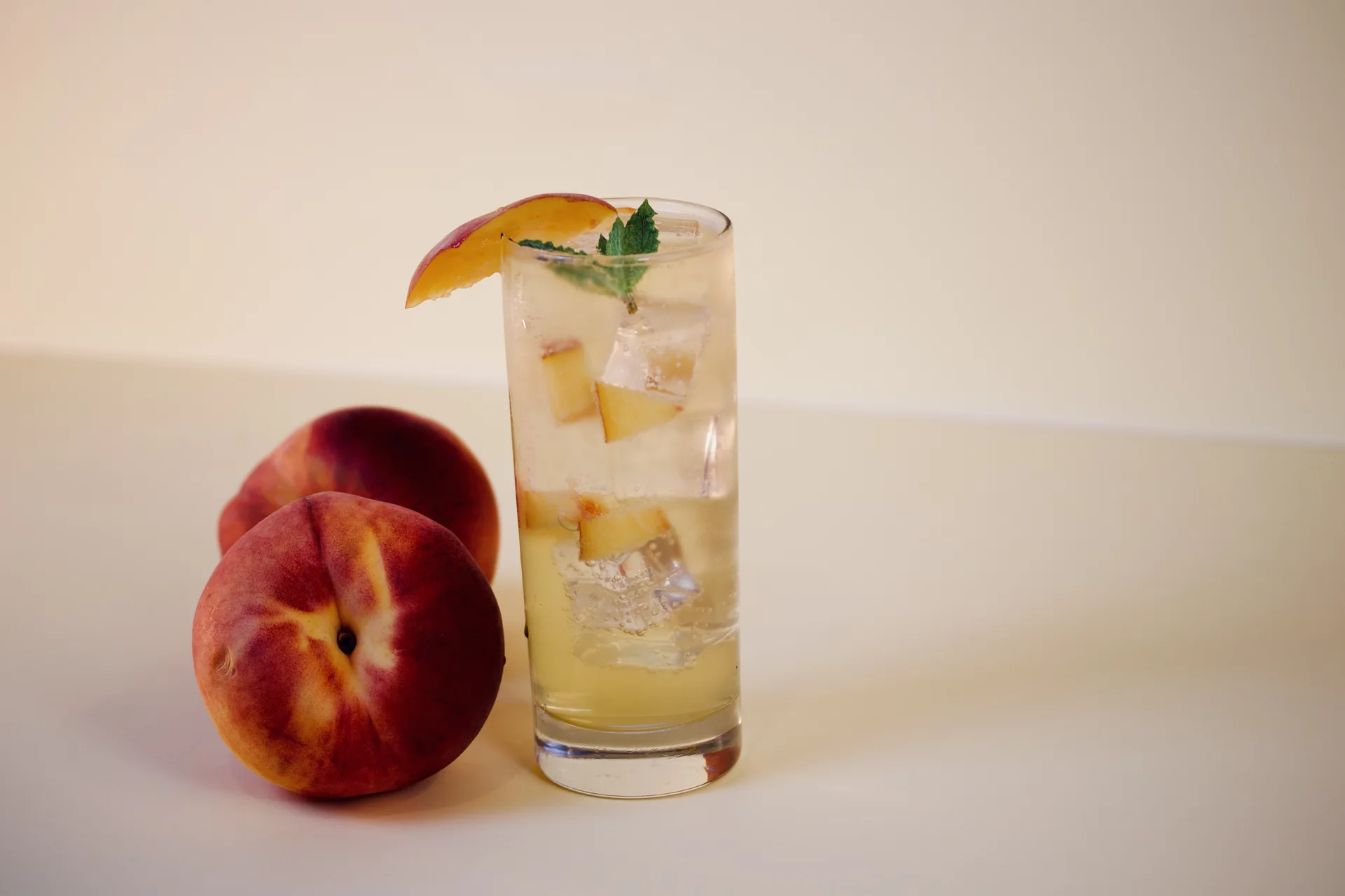 Peach-toned sparkling drink with fresh peach and mint